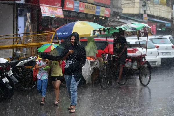 NEW DELHI INDIA 19 HAZİRAN 2023 19 Haziran 2023 Bir öğleden sonra Jangpura bölgesinde yağmur sırasında sokaklardan geçen insanlar 19 Haziran 2023 'te Yeni Delhi Hindistan' da 24 saat boyunca 5 mm yağmur yağdı.