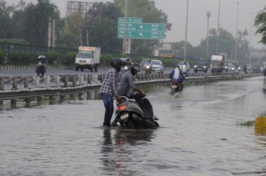 GURUGRAM INDIA 28 Haziran 2023 Bir adam yağmurlu bir yolda motosikletini çekti 28 Haziran 2023 'te Sunbeam Company yakınlarındaki NH 48 servis yolunda Parveen Kumar Hindustan Times tarafından çekilmiştir. 