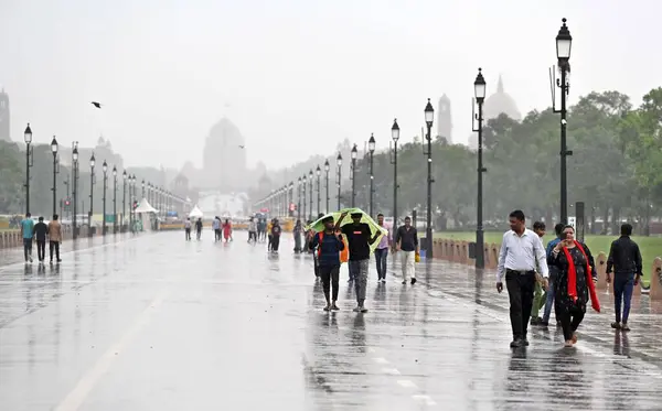 stock image NEW DELHI INDIA JUNE 30 2023 People walk amid monsoon rainfall at Kartavya Path on June 30 2023 in New Delhi India Heavy rains lashed Delhi NCR leading to waterlogging in several areas and traffic snarls Photo by Sanjeev Verma Hindustan Times 