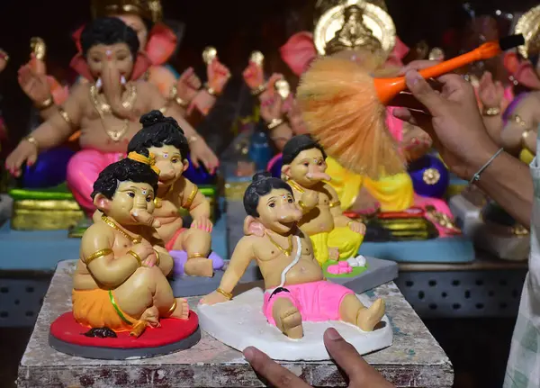 MUMBAI INDIA 28 AĞUSTOS 2024 Bir sanatçı, 28 Ağustos 2024 'te Mumbai Hindistan' da yapılacak Ganesh Chaturthi festivali için Ganesha heykeline son rötuşlarını yapıyor.