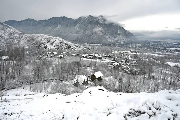 stock image SRINAGAR INDIA FEBRUARY 1 2024 People walk after a seasons first snowfall in the outskirts of Srinagar India It is the seasons first snowfall in the plains of the Kashmir valley