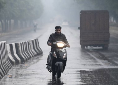 3 Şubat 2024 'te Noida Hindistan' da 3125. Sektör 'de hafif yağmurlarda görülen NOIDA INDIA FEBRUARY 3. 2024 Commuters. Fotoğraf: Sunil Ghosh Hindustan Times 