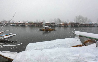 SRINAGAR INDIA FEBRUARY 4 2024 A boatman crosses Dal Lake during a snowfall on February 4 2024 in Srinagar India Several parts of Kashmir including Srinagar city witnessed fresh snowfall as the MeT department has forecast moderate topheavy snowfall i clipart