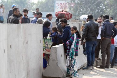 YENİ DELHI INDIA ŞUBAT 14. 2024 İnsanlar Singhu sınırı yakınlarındaki beton barikatlardan geçerek 14 Şubat 2024 tarihinde Yeni Delhi Hindistan 'da gerçekleştirilen Delhi Chalo yürüyüşü neticesinde güvenlik düzenlemeleri kapsamında