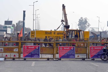 NEW DELHI INDIA FEBRUARY 14 2024 Police remove Welcome to Delhi signboard as security arrangements have been tightened near the Singhu border in view of farmers Delhi Chalo march on February 14 2024 in New Delhi India Massive deployments of police an clipart