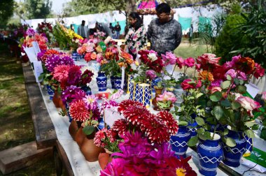 NEW DELHI INDIA FEBRUARY 18 2024 Visitors take selfies and photos with flowers during the 36th Garden Tourism Festival organized by Delhi Tourism in collaboration with the Delhi Government held at Garden of Five Senses on February 18 2024 in New Delh clipart