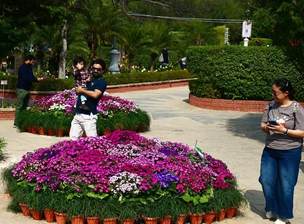 stock image NEW DELHI INDIA FEBRUARY 18 2024 Visitors take selfies and photos with flowers during the 36th Garden Tourism Festival organized by Delhi Tourism in collaboration with the Delhi Government held at Garden of Five Senses on February 18 2024 in New Delh