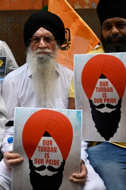 KOLKATA INDIA FEBRUARY 21 2024 Members of the Sikh community hold poster our turban is our pride during 2nd day sitin dharna in front of BJP Party headquarters to protest against the alleged Khalistani jibe at IPS officer by BJP leaders and demand ap clipart