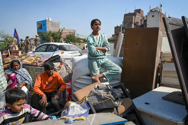 stock image NEW DELHI INDIA FEBRUARY 28 2024 Affected family members with their belongings as officials from the forest department along with the Delhi Police seen carrying out a demolition drive alongside the forest land at H Block Sangam Vihar on February 28 2