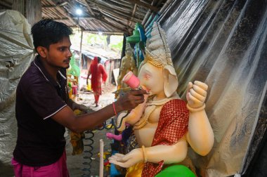 NoIDA İNDİYA 4 Eylül 2024 Bir sanatçı Ganesha putlarına Noida Hindistan 'daki Ganesh Chaturthi festivali öncesinde son rötuşlarını yapıyor. Fotoğraf: Sunil Ghosh Hindustan Times 