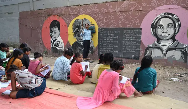 stock image NEW DELHI INDIA SEPTEMBER 3 2024 Teacher Rajesh Sharma Laxmi Chandra Shyam Mahto teaching under privileged children for free at under the metro pillar Yamuna Bank Metro Station Photo by Sonu Mehta Hindustan Times 