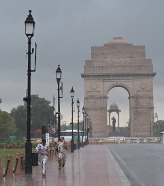 NEW DELHI, INDIA - 4 Eylül 2024 tarihinde Yeni Delhi, Hindistan 'da, Kartavya Yolu' ndaki yoğun çiseleme sırasında ziyaretçiler. Şiddetli yağış şehrin çeşitli bölgelerini kasıp kavururken Delhi sakinleri ani bir hava değişimine tanık oldular. 