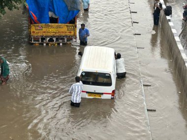 GURUGRAM, INDIA - 4 Eylül 2024 'te Gurugram, Hindistan' da, Subhash Chowk yakınlarındaki 33. bölgede, yağmurlu bir yolda araçlar su dolu bir yolda yürüdü. Delhi-NCR sakinleri ani bir değişikliğe tanık oldular