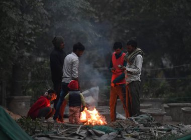 NEW DELHI INDIA JANUARY 12024 Mayur Vihar yakınlarındaki soğuk bir kış sabahında kendilerini korumak için şenlik ateşi etrafında insanlar Meteoroloji Bölümü, yoğun sisin Delhi NCT 'de önümüzdeki iki gün boyunca beklendiğini söyledi.