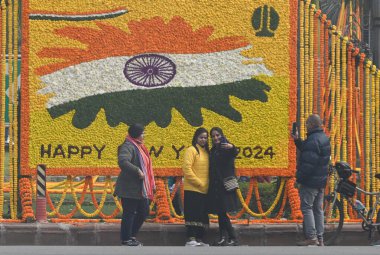 YENİ DELHI INDIA JANUARY 12024 İnsanlar Hindistan Kapısı ve Kartavaya Yolu 'nda toplanıp Vipin Kumar Hindustan Times' ın yeni yıl fotoğrafını kutlarken çiçek kalabalığı önünde selfie çekiyorlar. 