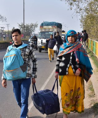 GHAZIABAD INDIA JANUARY 2 2024 People walking on foot as buses and autos are not running on GT Road near loha mandi on January 2 2024 in Ghaziabad India Commercial vehicle drivers on Monday staged massive protests in several states across the country clipart