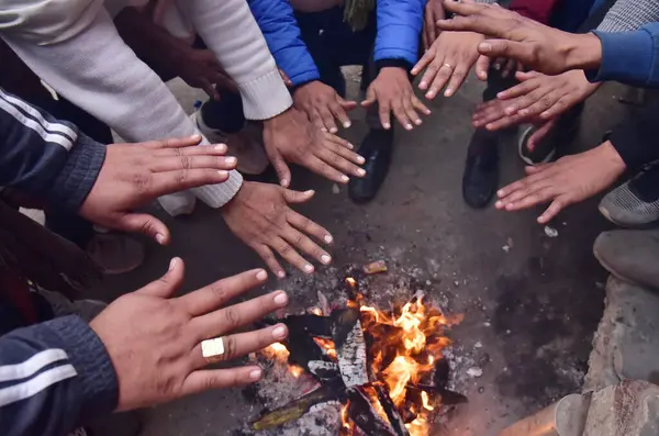 GHAZIABAD INDIA JANUARY 3. 2024 İnsanlar 3 Ocak 2024 'te Hindistan' ın Gaziabad şehrinde soğuk bir kış sabahı usman kolonisinde ısınmak için şenlik ateşinin yanında otururlar. Fotoğraf: Sakib Ali Hindustan Times 