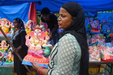 NEW DELHI, INDIA - 4 EPTEMBER: sanatçılar Yeni Delhi, Hindistan 'da 4 Eylül 2024 tarihinde, Ashok Park' ta yağmurdan korumak için Tanrı Ganesh İdollerini plastikle kaplarlar. 