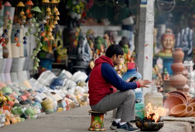 NOIDA İNDİYA JANUARY 4 2024 Bir adam kendini soğuktan korumak için şenlik ateşinin yanında IMD Delhi NCR 'ye göre önümüzdeki birkaç gün içinde minimum sıcaklığın 7 dereceye ulaştığı 3 Ocak' ta Sunil Ghosh Hindu tarafından çekilmiştir.