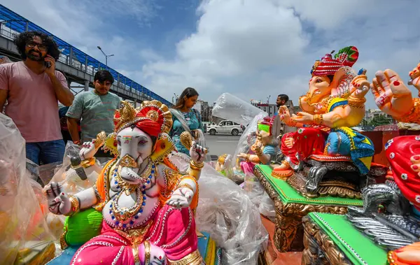 NEW DELHI, INDIA - 4 EPTEMBER: sanatçılar Yeni Delhi, Hindistan 'da 4 Eylül 2024 tarihinde, Ashok Park' ta yağmurdan korumak için Tanrı Ganesh İdollerini plastikle kaplarlar. 