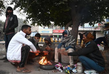 GURUGRAM INDIA JANUARY 6. 2024 İşçi Partisi, soğuk bir kış sabahı Buteshwar Mandir Foggy yakınlarındaki İşçi Mahallesi 'nde bir şenlik ateşinin etrafında ısınıyor. Sabah Delhi NCR' ye meydan okuyor.