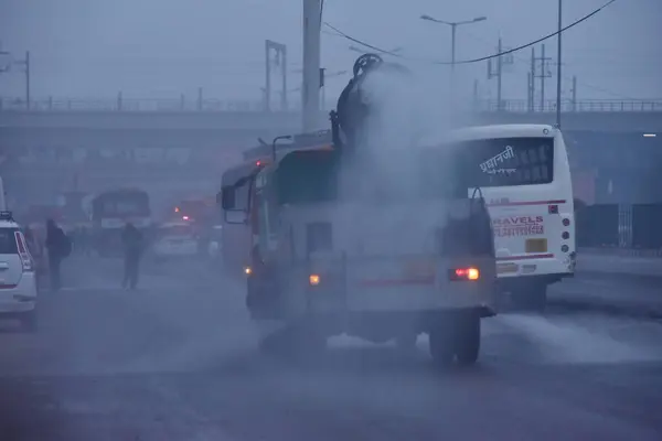 stock image NEW DELHI INDIA JANUARY 6 2024 An anti smog gun mounted on a vehicle sprays water into the atmosphere to reduce dust pollution as pollution levels risen at Anand Vihar Foggy morning challenges Delhi NCR with intensifying cold wave mercury dips furthe