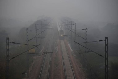 GURUGRAM INDIA JANUARY 11 2024 Bir yolcu treni Rewari 'den Delhi Sarai Rohilla' ya Dhankot Tren İstasyonu yakınlarındaki yoğun sisli havada Parveen Kumar Hindustan Times 