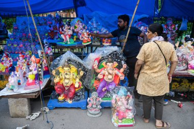 NOIDA, INDIA - SEPTEMBER 6: People buy idols of Lord Ganesha ahead of Ganesh Chaturthi festival at sector 20, on September 6, 2024 in Noida, India.  clipart