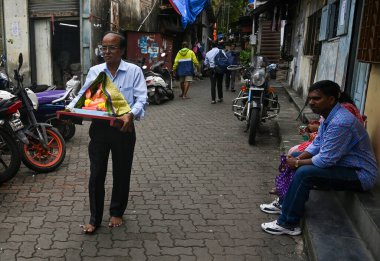 MUMBAI, INDIA - 6 Eylül 2024 'te Hindistan' ın Mumbai kentinde Ganesh Chaturthi festivali öncesinde Hindu tanrısı Ganesha 'nın heykelini bir atölyeden eve taşır.. 