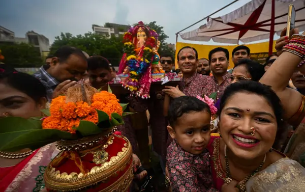 stock image NEW DELHI, INDIA - SEPTEMBER 7: Devotees carry Lord Ganesha idols on the occasion of Ganesh Chaturthi in Lovely Public Senior Secondary School, Laxmi Nagar on September 7, 2024 in New Delhi, India. 