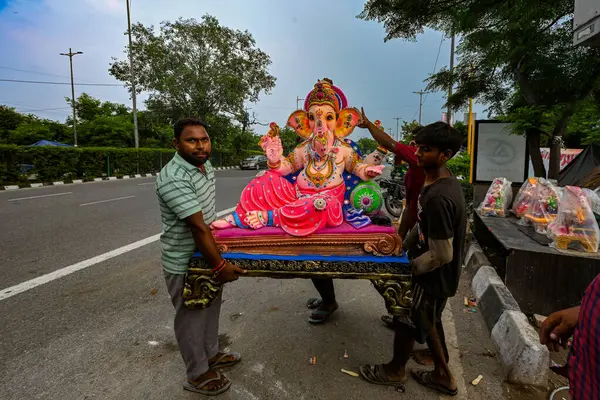 stock image NEW DELHI, INDIA - SEPTEMBER 7: Devotees carry Lord Ganesha idols on the occasion of Ganesh Chaturthi in Lovely Public Senior Secondary School, Laxmi Nagar on September 7, 2024 in New Delhi, India. 