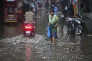 NEW DELHI, INDIA - 9 Eylül 2024 'te, Yeni Delhi, Hindistan' da, Mayur Vihar yakınlarındaki Dallupura 'da yağan yağmurdan sonra yerel halk su dolu bir alanda yürüdü.. 