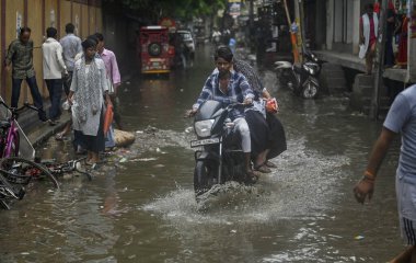 NEW DELHI, INDIA - 9 Eylül 2024 'te, Yeni Delhi, Hindistan' da, Mayur Vihar yakınlarındaki Dallupura 'da yağan yağmurdan sonra yerel halk su dolu bir alanda yürüdü.. 