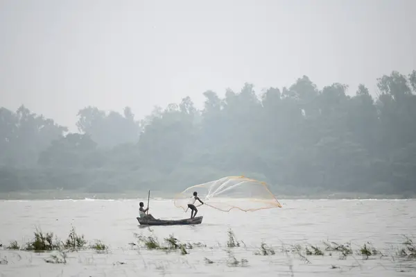 stock image NOIDA INDIA SEPTEMBER 7 2024 A fisherman throwing a net to catch fish in the Yamuna River The water level of the river has increased during the rainy season on September 7 2024 in Noida India Photo by Sunil Ghosh Hindustan Times 