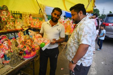 NOIDA INDIA SEPTEMBER 6 2024 People buy idols of Lord Ganesha ahead of Ganesh Chaturthi festival at sector 20 on September 6 2024 in Noida India Ganesh Chaturthi is celebrated across the country to mark the birth of the god associated with wisdom and clipart