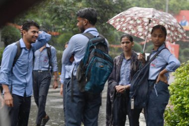 NEW DELHI INDIA SEPTEMBER 4 2024 Okul Öğrencileri 4 Eylül 2024 tarihinde DDU Marg 'da yoğun çiseleme sırasında Yeni Delhi' de yaşayan Delhi sakinleri, şiddetli yağmurun şehrin çeşitli bölgelerini kasıp kavurduğu bir hava değişimine tanık oldular.