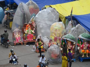 NEW DELHI INDIA 4 EPTEMBER 4 2024 Sanatçılar kendilerini Yeni Delhi 'de 4 Eylül 2024' te Ashok Park 'ta yağmurdan korumak için Tanrı Ganesh İdollerini plastikle kaplıyorlar. Delhi sakinleri, şiddetli yağmurun bazı bölgelerine vurduğu hava değişimine tanık oldular.