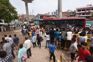 NEW DELHI INDIA JULY 2 2023 Police personnel and local people standing after demolition of two religious structures for construction of a flyover at Bhajanpura Chowk area Ring road on July 2 2023 in New Delhi India A Hanuman temple and a Dargah were  clipart