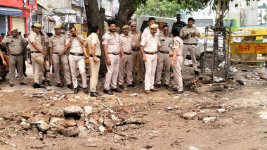 YENİ DELHI INDIA 2 Temmuz 2023 Polis personeli ve yerel halk Bhajanpura Chowk bölgesinde 2 Temmuz 2023 'te Yeni Delhi' de bir Hanuman tapınağı ve bir Dargah 'ın inşası için iki dini yapının yıkılması sonrasında ayakta kaldı. 