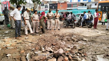 NEW DELHI INDIA JULY 2 2023 Police personnel and local people standing after demolition of two religious structures for construction of a flyover at Bhajanpura Chowk area Ring road on July 2 2023 in New Delhi India A Hanuman temple and a Dargah were  clipart