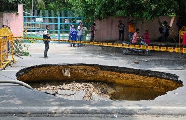 NEW DELHI INDIA JULY 5 2023 A large portion of a road in west Delhis Janakpuri caved in due to leakage of a sewer line officials said on July 5 2023 in New Delhi India The road caved in due to the leakage of a sewer line of the Delhi Jal Board Two pi clipart