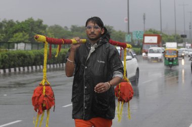 GURUGRAM INDIA 8 Temmuz 2023 Kanwar Yatra 'daki Hindu müritleri kutsal ay olan Rajiv Chowk yakınlarındaki Shravan' da Ganj Nehri 'nden kutsal su taşırken 8 Temmuz 2023' te Gurugram Hindistan 'da Delhi NCR şiddetli yağmurla sırılsıklam olmuştu.