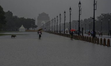 YENİ DELHI INDIA 8 HAZİRAN 2023 Suyun içinde yürüyen insanlar 8 Temmuz 2023 tarihinde Hindistan Kapısı 'ndaki şiddetli yağış sonrası Central Vista Lawns' ta yürüyorlar. 