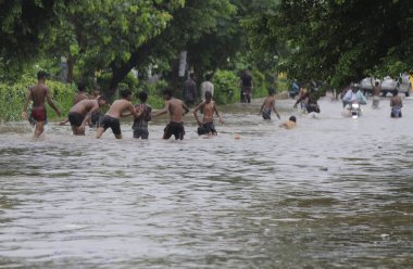 9 Temmuz 2023 'te Gurugram Hindistan' da Tau Devi Lal Stadyumu yakınlarındaki 38. Mıntıka 'da muson yağmurlarının ardından su altında oynayan çocuklar Cuma gecesi şiddetli bir yağmurla sırılsıklam oldular.