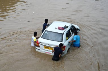 GURUGRAM INDIA 9 Temmuz 2023 'te Hindistan Gurugram Delhi NCR' de, 9 Temmuz 2023 'te Sadar Polis Merkezi yakınlarındaki Subhash Chowk' ta yağmur altında bir arabayı suya iterken görüldü.