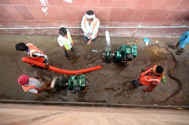 GURUGRAM INDIA JULY 9 2023 Workers trying to drain out the water using pumps from Subway underpass after water gets logged in amid monsoon rains at National Highway 48 near Anaj Mandi on July 9 2023 in Gurugram India Delhi NCR was drenched with heavy clipart