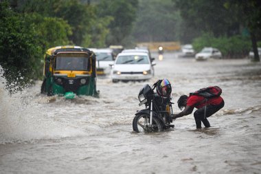 NEW DELHI INDIA JULY 9 2023 Commuters seen moving through water logged street after heavy rains at Bhairav Marg on July 9 2023 in New Delhi India Delhi NCR was drenched with heavy rain on the intervening night of Friday Saturday and Sunday The overni clipart