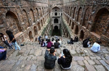 NEW DELHI INDIA - 11 Eylül 2024 'te Hindistan' ın Yeni Delhi kentinde, Connaught Place yakınlarındaki Hailey Yolu 'ndaki tarihi eser Ugrasen ki Baoli' de ziyaretçiler eğleniyor 