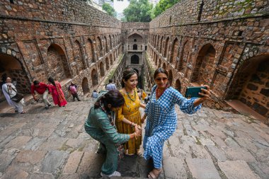 NEW DELHI INDIA - 11 Eylül 2024 'te Hindistan' ın Yeni Delhi kentinde, Connaught Place yakınlarındaki Hailey Yolu 'ndaki tarihi eser Ugrasen ki Baoli' de ziyaretçiler eğleniyor 