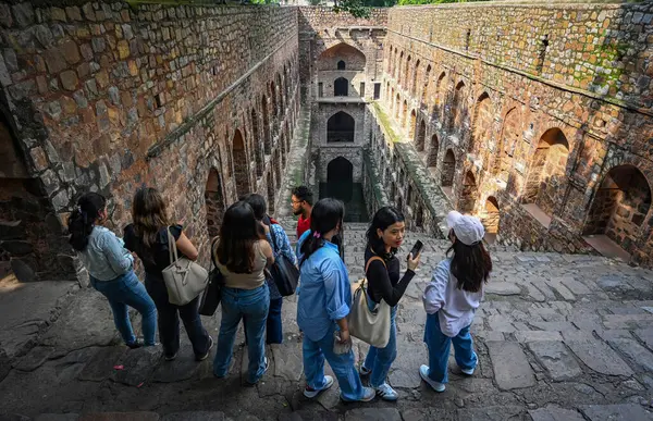 NEW DELHI INDIA - 11 Eylül 2024 'te Hindistan' ın Yeni Delhi kentinde, Connaught Place yakınlarındaki Hailey Yolu 'ndaki tarihi eser Ugrasen ki Baoli' de ziyaretçiler eğleniyor 